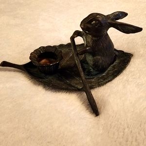 Vintage bronze bunny padding on a leaf boat candle holder